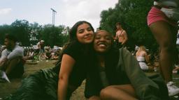 two people smiling and posing for a picture in a field 